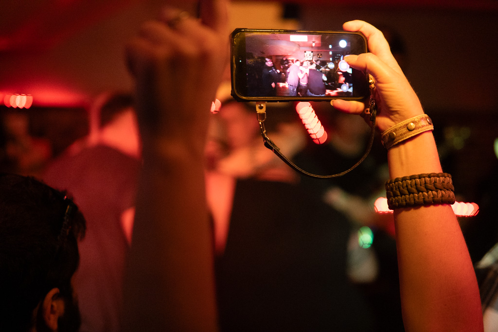 Fan holding up a phone to record the set